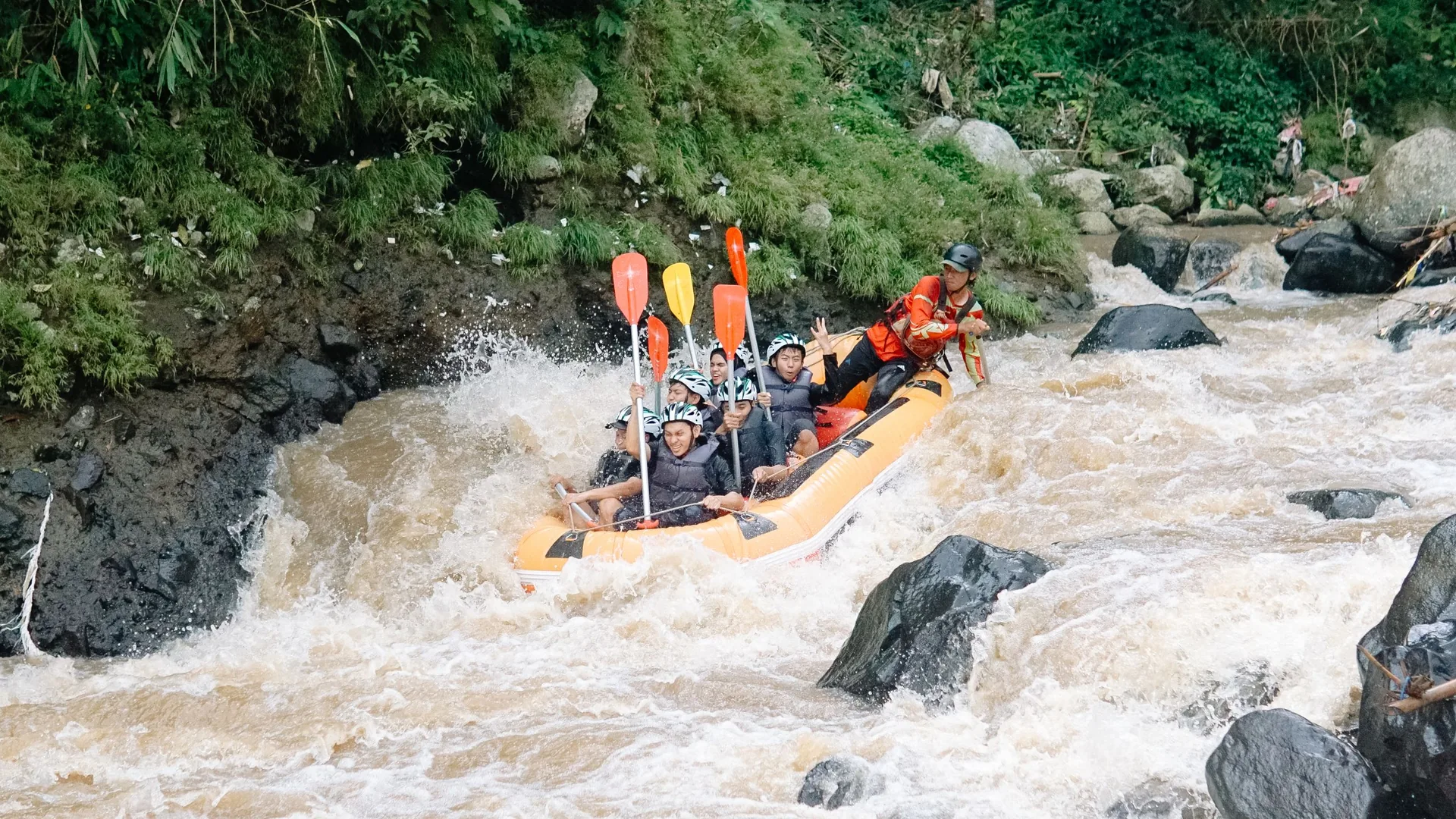 A raft crew paddling through jungle white water on Bali's Ayung River