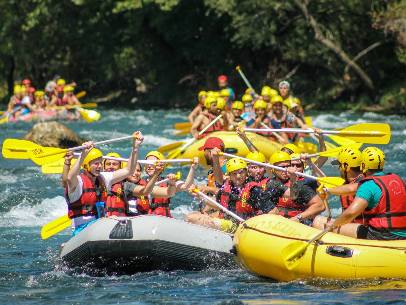 A group in helmets and life jackets paddling a raft on the Ayung River